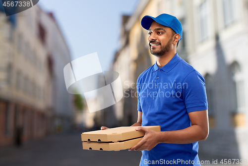 Image of happy indian delivery man with pizza boxes in city