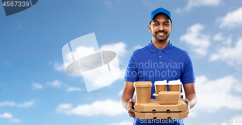 Image of happy indian delivery man with food and drinks