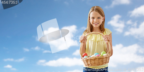 Image of happy girl with colored eggs in wicker basket