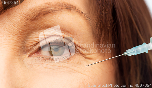 Image of close up of senior woman face and syringe