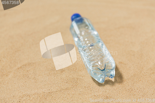 Image of bottle of water on beach sand