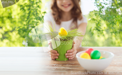 Image of close up of girl with toy chicken in flowerpot