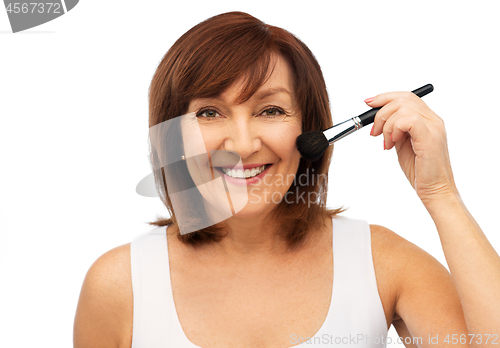 Image of smiling senior woman with make up blush brush