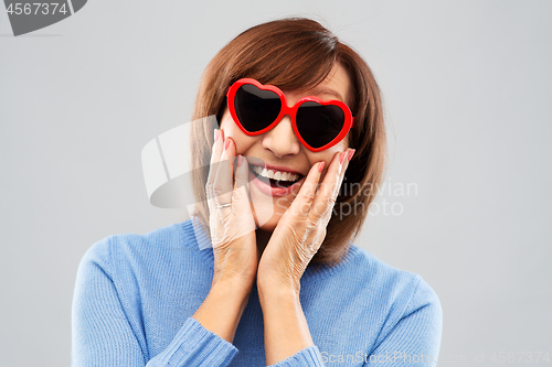 Image of smiling senior woman in heart-shaped sunglasses