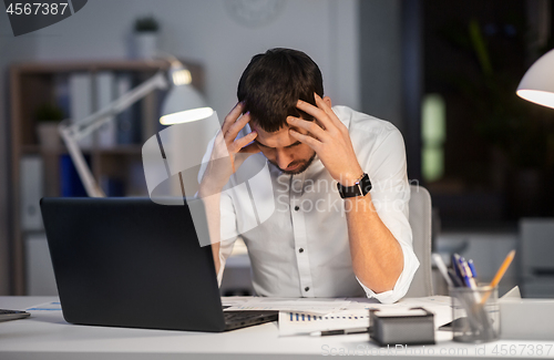 Image of businessman with papers working at night office