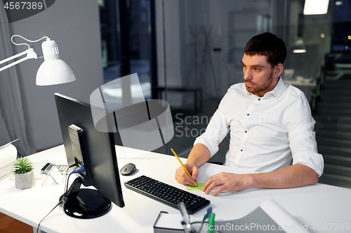 Image of businessman with computer working at night office