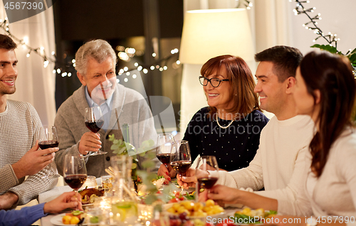 Image of happy family having dinner party at home