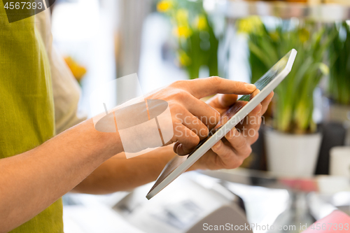 Image of seller with tablet computer at flower shop