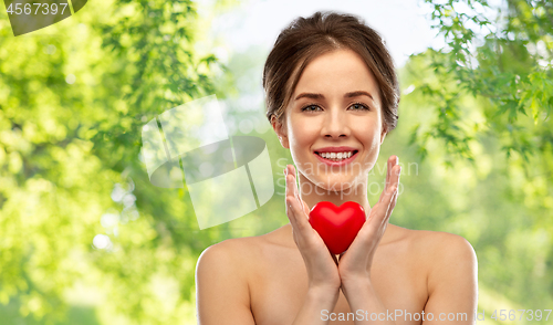 Image of beautiful smiling woman holding red heart