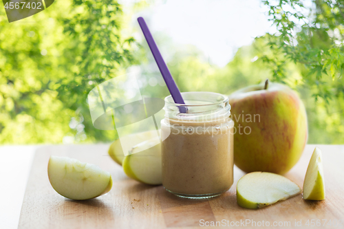 Image of jar with apple fruit puree or baby food on table