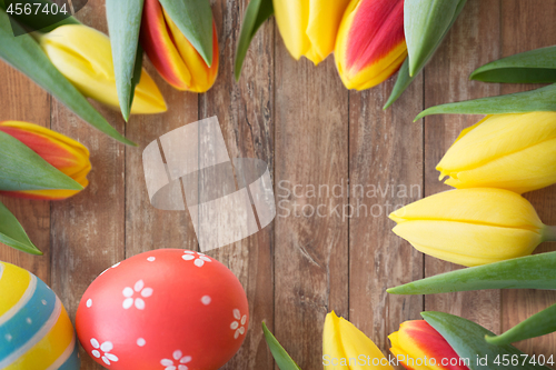 Image of close up of colored easter eggs and tulip flowers