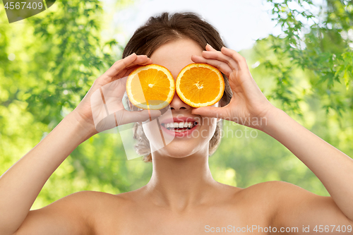 Image of smiling woman with oranges over grey background