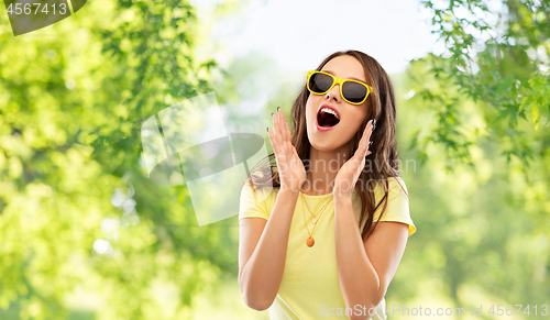 Image of amazed teenage girl in yellow sunglasses