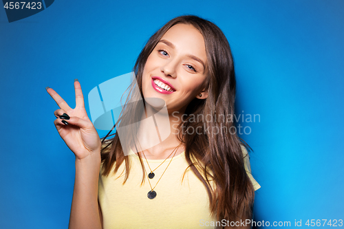 Image of young woman or teenage girl showing peace sign