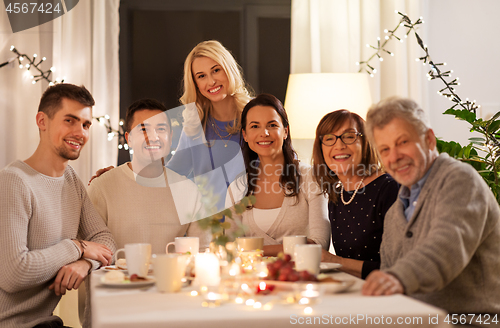 Image of happy family having tea party at home