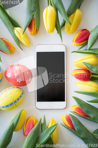 Image of smartphone with easter eggs and tulip flowers