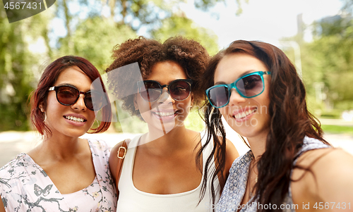 Image of happy young women in sunglasses at summer park