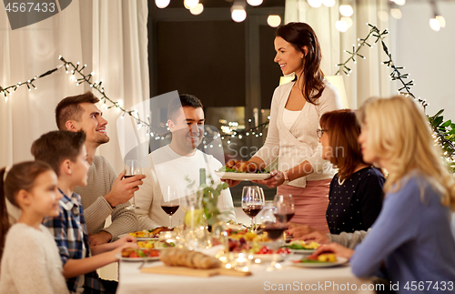 Image of happy family having dinner party at home