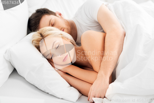 Image of happy couple sleeping in bed at home