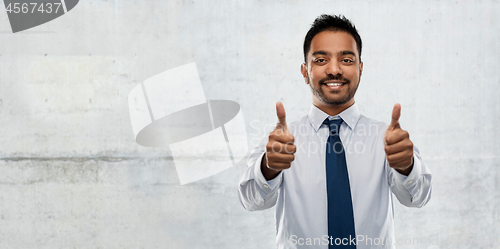 Image of indian businessman showing thumbs up over concrete