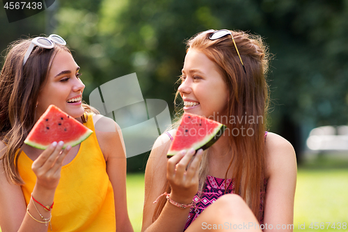 Image of teenage girls eating watermelon at picnic in park