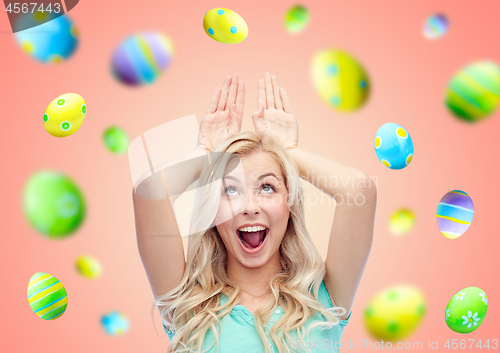 Image of happy smiling young woman making easter bunny ears