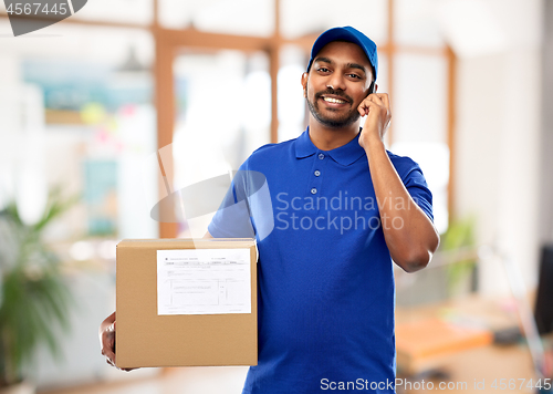 Image of indian delivery man with smartphone and parcel box