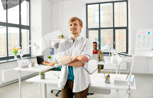 Image of happy smiling man with glasses at office