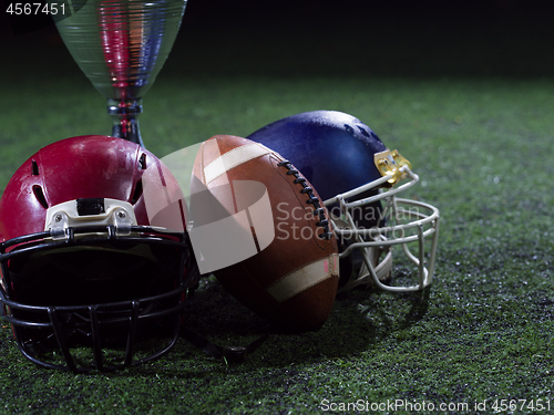 Image of closeup of american football,helmets and trophy