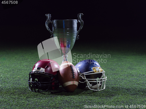 Image of closeup of american football,helmets and trophy