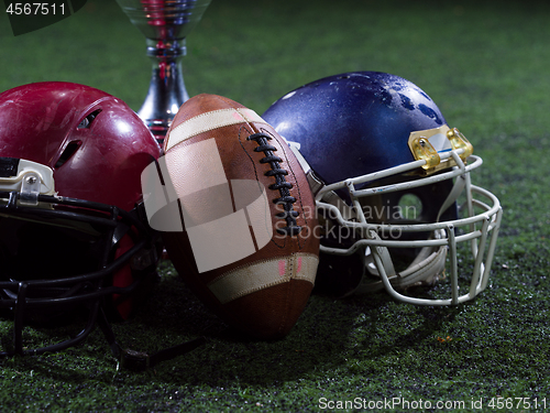 Image of closeup of american football,helmets and trophy