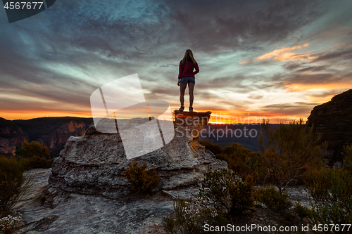 Image of Female hiker taking in heavenly views of mountains and valleys