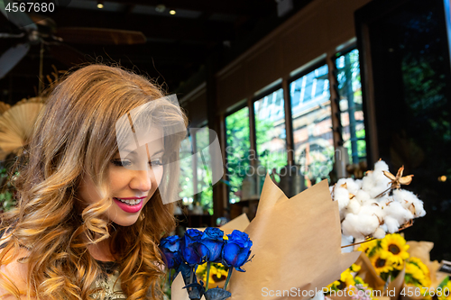 Image of Customer buying or admiring a bunch of blue roses