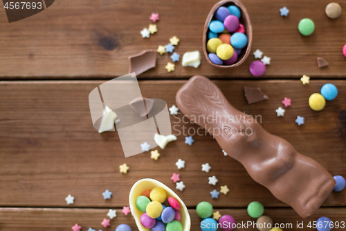 Image of chocolate eggs, easter bunny and candies on wood
