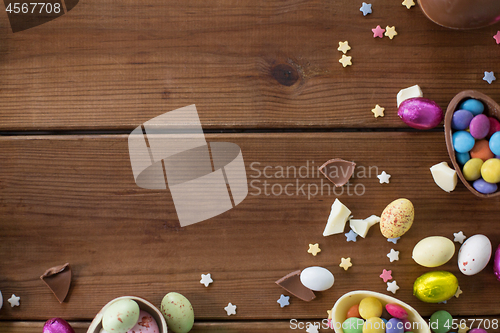 Image of chocolate eggs and candy drops on wooden table