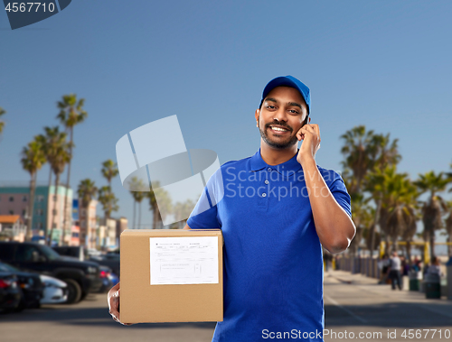 Image of indian delivery man with smartphone and parcel box