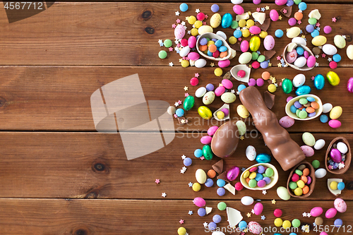 Image of chocolate eggs, easter bunny and candies on wood