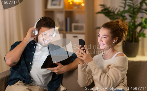 Image of couple with gadgets listening to music at home