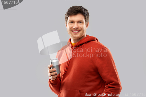Image of happy young man drinking soda from tin can