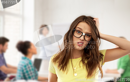 Image of confused teenage student girl in glasses at school