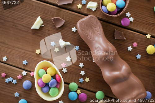 Image of chocolate eggs, easter bunny and candies on wood