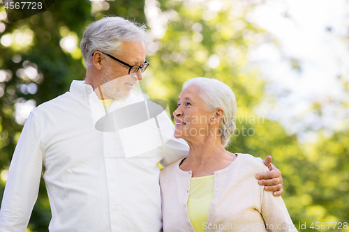 Image of happy senior couple hugging at summer park