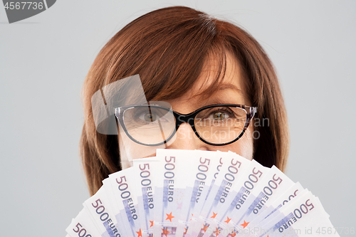 Image of senior woman holding hundred euro money banknotes
