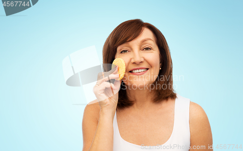 Image of woman cleaning face with exfoliating sponge