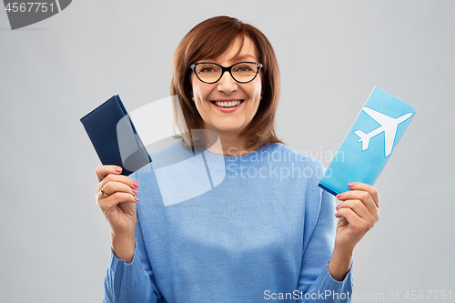 Image of senior woman with passport and airplane ticket