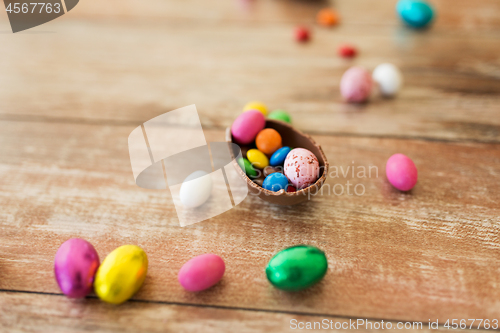 Image of chocolate egg and candy drops on wooden table