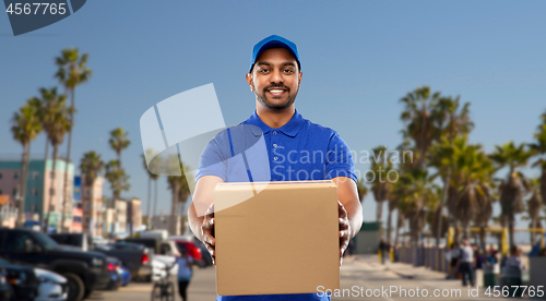 Image of happy indian delivery man with parcel box in blue