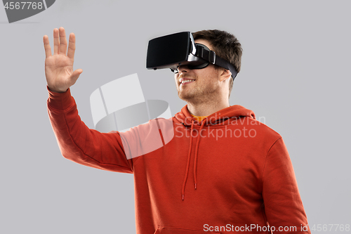 Image of happy man in virtual reality headset or vr glasses