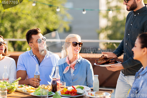 Image of friends at bbq party on rooftop in summer