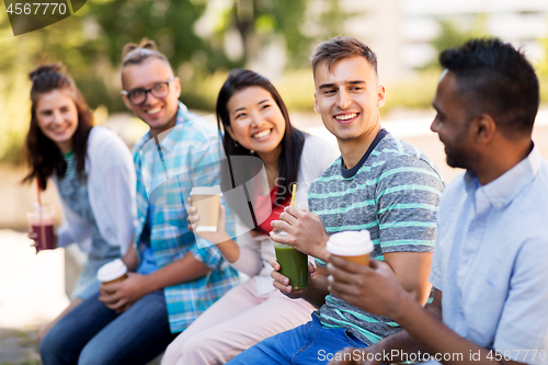 Image of friends drinking coffee and juice talking in city